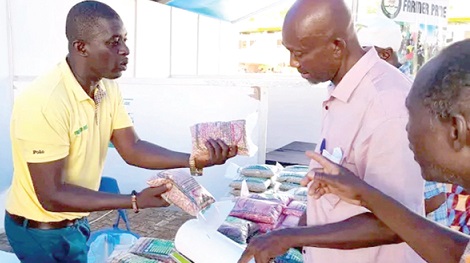 Charles Soyiri, a Busa-based farmer in the Wa municpality, inspecting some products during the exhibition